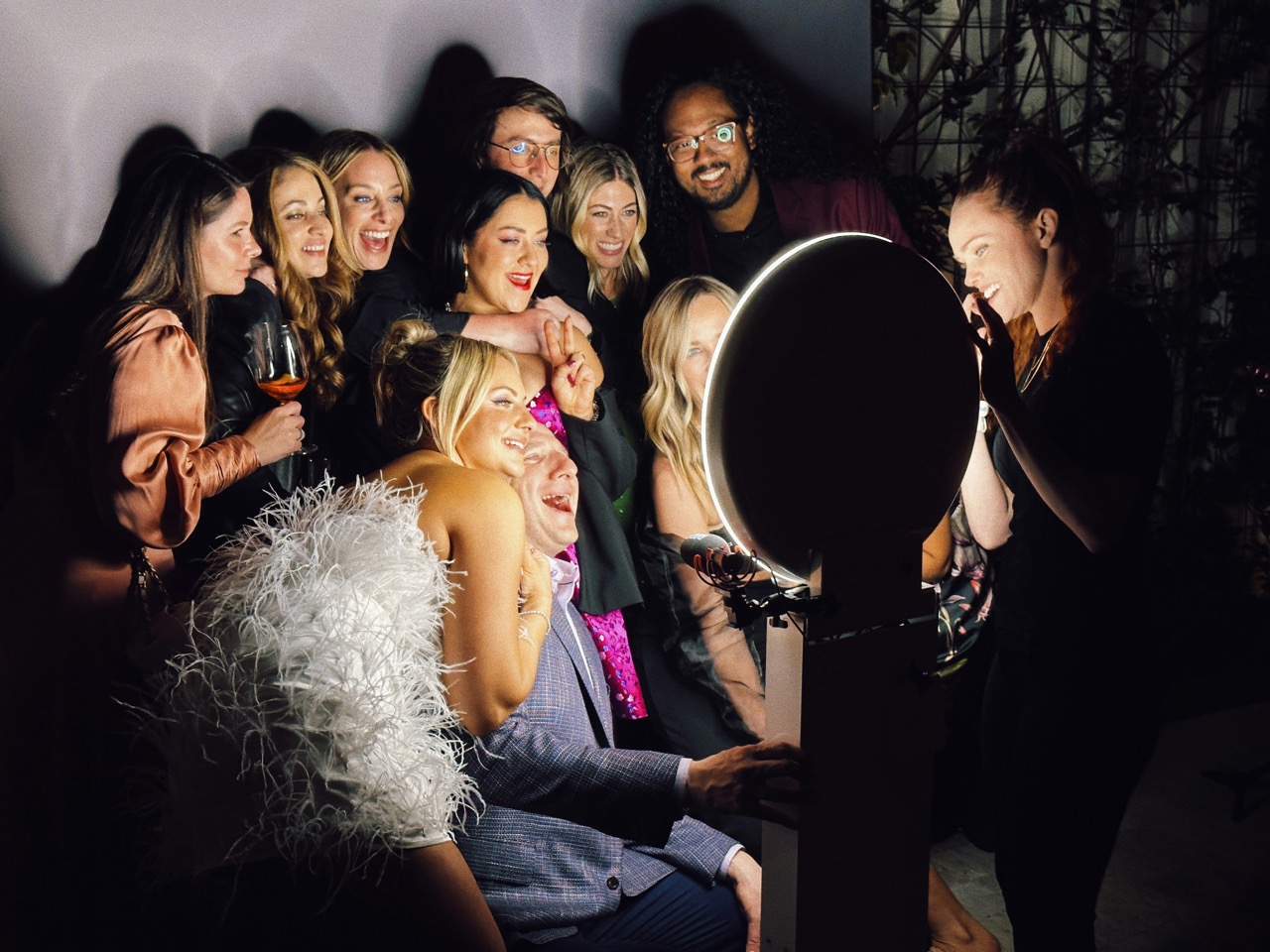 Group of guests posing together at a luxury event using a ring light photo booth.